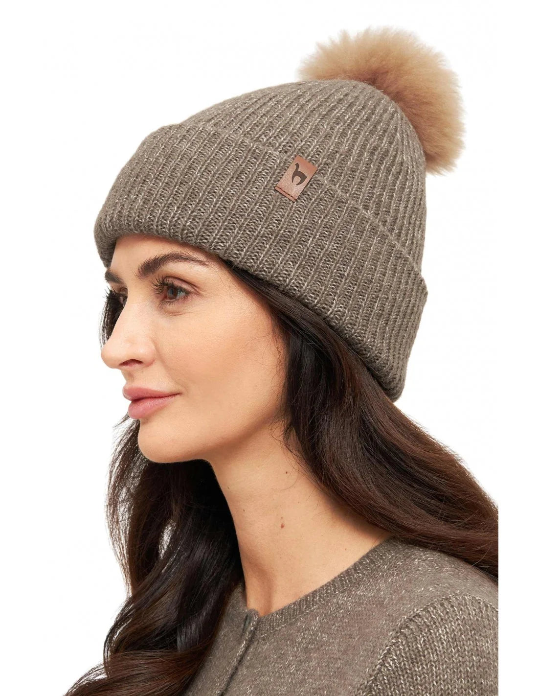 Detailansicht Mütze PACA – flauschiger Fellbommel und edles Leder-Label im Rippstrick